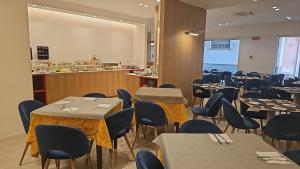 a restaurant with tables and chairs and a counter at Hotel Fernanda in Letojanni