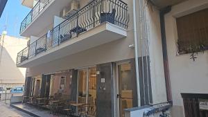 a building with tables and chairs on a balcony at Hotel Fernanda in Letojanni