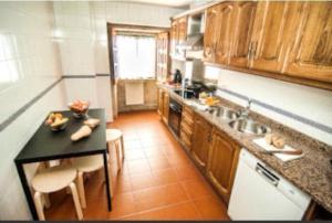 a kitchen with a black counter top and wooden cabinets at Casa rural La rectoral in Areas