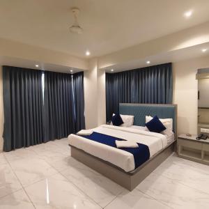 a bedroom with a large bed with black curtains at Marina Executive Rooms in Navi Mumbai