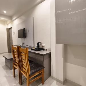 a room with a desk with a chair and a microwave at Marina Executive Rooms in Navi Mumbai
