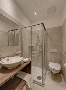 a bathroom with a sink and a shower and a toilet at Pension Irma in Caldaro +39 photos