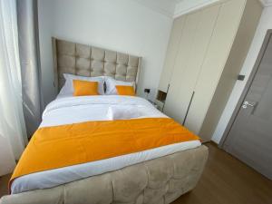 a bedroom with a large bed with an orange blanket at Meteor Garden in Nairobi +31 photos