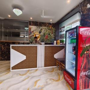 a man standing at a bar with a cocacola machine at Marina Executive Rooms in Navi Mumbai