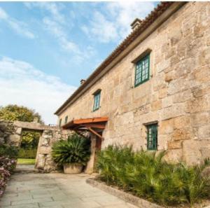 a large stone building with a courtyard in front at Casa rural La rectoral in Areas