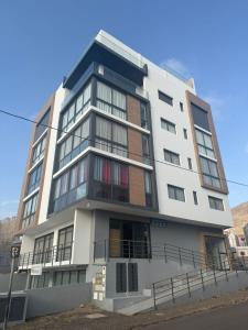 a tall white building with many windows at Comfortable 2-Bedroom Apartment, Monte Sossego in Mindelo