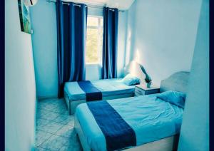 a small room with two beds and a window at Blue Haven in Grand-Baie