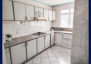 a white kitchen with white cabinets and a window at Blue Haven in Grand-Baie