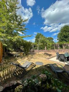 a patio with chairs and tables in a yard at La Maison de Gautro in Tréhorenteuc