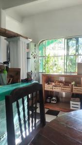 a room with a table and a bench and windows at Jungle Palace hostal santaella in Puerto Escondido