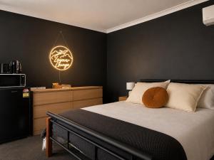 a bedroom with a bed and a black wall at Layover Lounge in Perth +5 photos