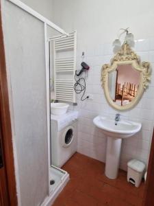 a white bathroom with a sink and a mirror at Attico le due Torri in Arezzo