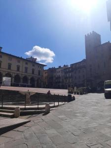 a group of benches in a courtyard with buildings at Attico le due Torri in Arezzo