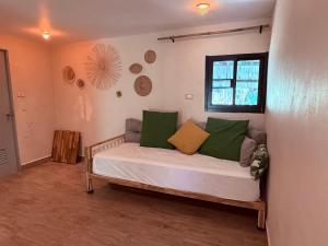 a bedroom with a bed with green and yellow pillows at Star Fish Cozy House in Ban Nua