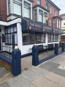 a hotel with two fire hydrants in front of a fence at The Hotel Blackpool in Blackpool