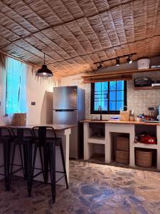 a kitchen with a table and a refrigerator at Star Fish Cozy House in Ban Nua
