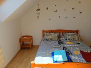 a bedroom with a bed with a blue comforter at La maison aux papillons in Tregueux