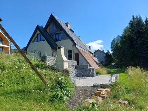 a house with a patio in front of it at Chaloupka na vršku in Loučná pod Klínovcem