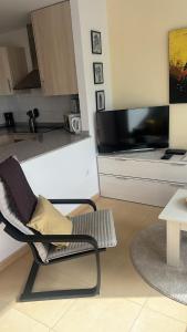 a living room with a chair and a television at Condado de Alhama N478 in Alhama de Murcia