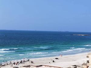 a group of people on a beach near the ocean at لؤلؤة البحر in Alexandria