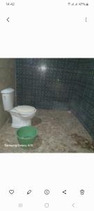 a bathroom with a toilet and a green bowl at J'adore House in Abémé