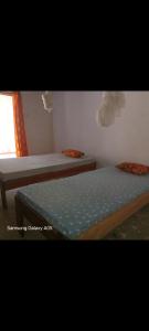 a bedroom with two beds and a window at J'adore House in Abémé