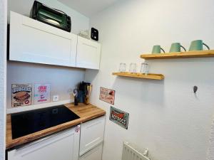 a kitchen with white cabinets and a counter top at See Apart 7 in Öhningen +4 photos