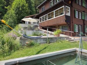 a house with a hammock in front of a house at Chalet Sonnenheim mit atemberaubender Aussicht in Adelboden