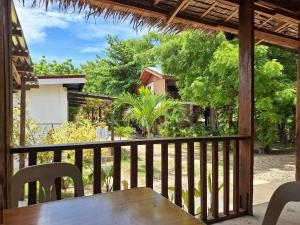a wooden table and chairs on a balcony at Basilia Guest House in Bantayan Island