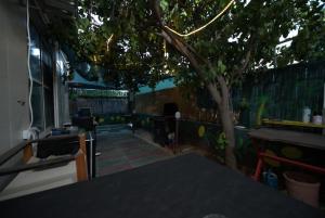 a view of a patio with a tree and a fence at The Lemon House in Tel Aviv