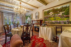 a dining room with two tables and a fireplace at Batavia Boutique Hotel in Stellenbosch