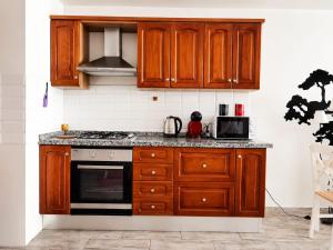 a kitchen with wooden cabinets and a stove top oven at Beachsunset apartamento para estancias temporales in Tacoronte