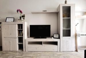 a living room with a tv and a white entertainment center at Beachsunset apartamento para estancias temporales in Tacoronte +4 photos