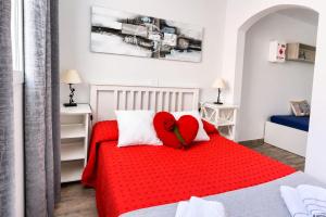 a red heart pillow on a bed in a bedroom at Beachsunset apartamento para estancias temporales in Tacoronte
