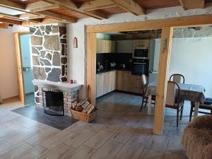a living room with a stone fireplace and a table at Chaloupka na vršku in Loučná pod Klínovcem