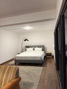 a bedroom with a white bed and a couch at Villa Clair de Lagon in Blue Bay +12 photos