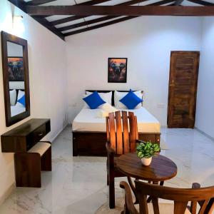 a bedroom with a bed and a table and a chair at Beach 365 in Nilaveli