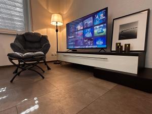 a living room with a chair and a large screen television at Ferienwohnung EG in Gräfenhainichen