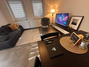a living room with a couch and a table and a television at Ferienwohnung EG in Gräfenhainichen