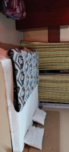a bed with a pile of sheets and pillows on it at Friends cottage in Coonoor
