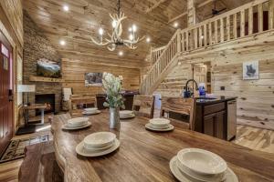 a dining room with a table and a kitchen at Cozy Log Cabin, hot tub, pool table, pool access in Gatlinburg