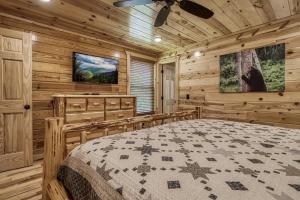 a bedroom with a bed and a ceiling fan at Cozy Log Cabin, hot tub, pool table, pool access in Gatlinburg +19 photos