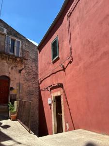 a red building with a door in front of it at Reusia Holiday Home in Ragusa +16 photos