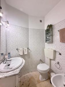 a white bathroom with a toilet and a sink at Cascais Historic Villa in Cascais