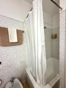 a bathroom with a tub and a toilet with a shower curtain at Cascais Historic Villa in Cascais
