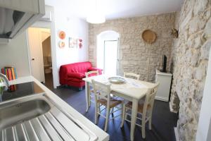 a kitchen and dining room with a table and chairs at Reusia Holiday Home in Ragusa