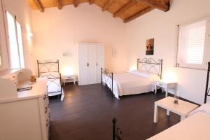 a bedroom with two beds and two tables in it at Reusia Holiday Home in Ragusa