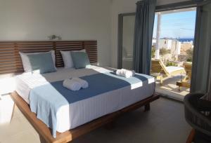 a bedroom with a large bed with towels on it at Villa Ploes in Agios Georgios