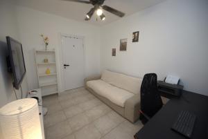a living room with a couch and a desk at The Lemon House in Tel Aviv