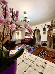 a living room with a couch and a vase with flowers at Casa hoinarului in Borca